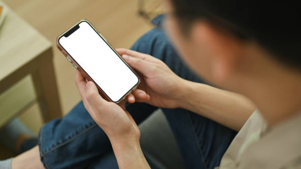 istock View over shoulder smartphone with blank screen in man hands. Empty space for your advertising text message. 1493106975