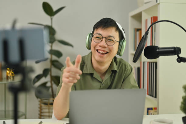istock Cheerful male podcaster wearing headphone streaming and broadcasting podcast from home studio. 1493107015