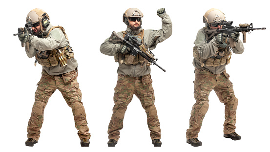 soldier in military equipment with a gun on a white isolated background, a commando in uniform with a gun to aim and attack