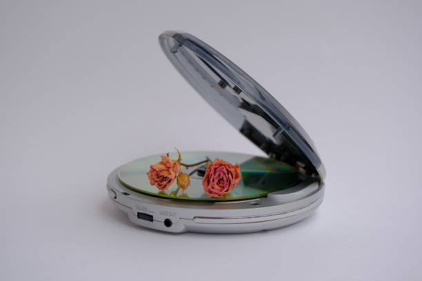 dry rose and CD player. dry rose lies on a portable compact disc player dry rose and CD player. dry rose lies on a portable compact disc player. CD player as vintage technology concept open cd player stock pictures, royalty-free photos & images