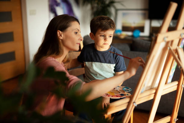 istock Little boy drawing with mom in living room. 1493111440