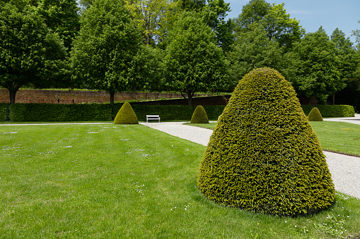 The way forward: path leads around a corner in a lush formal garden.