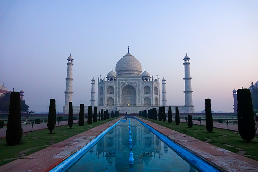 Fabulous Taj Mahal at sunrise with blue sky and no clouds when almost no people at all are in the monument's area.