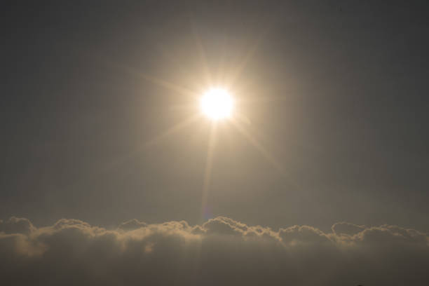 Sun in the middle with cloud underneath the clear blue summer sunny day