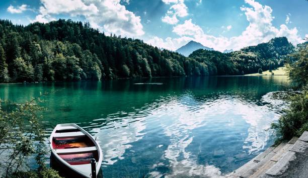 istock Small white boat on the side of a calm lake 1493118972