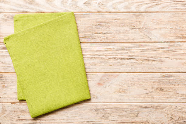 istock top view with green kitchen napkin isolated on table background. Folded cloth for mockup with copy space, Flat lay. Minimal style 1493119948