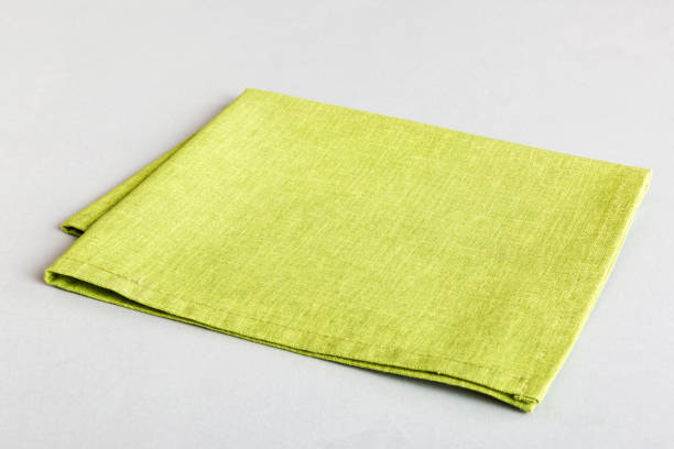 istock top view with green kitchen napkin isolated on table background. Folded cloth for mockup with copy space, Flat lay. Minimal style 1493119971