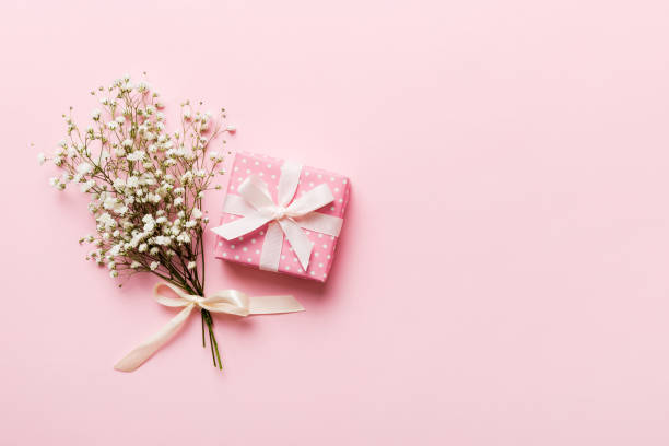 istock Gift or present box and flower gypsophila on light table top view. Greeting card. Flat lay style with copy space 1493120083