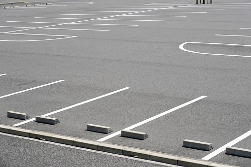 Empty space outdoor asphalt car parking lot (white line and concrete wheel stopper). Traffic and transportation concept.