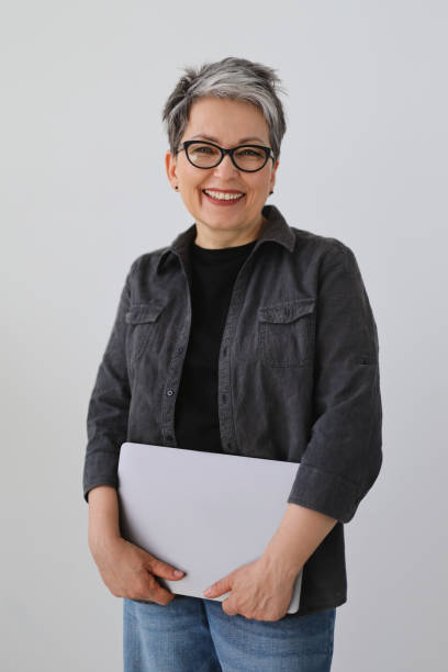 istock Laughing senior woman with a laptop in her hands, an experienced programmer and a professional. 1493120692