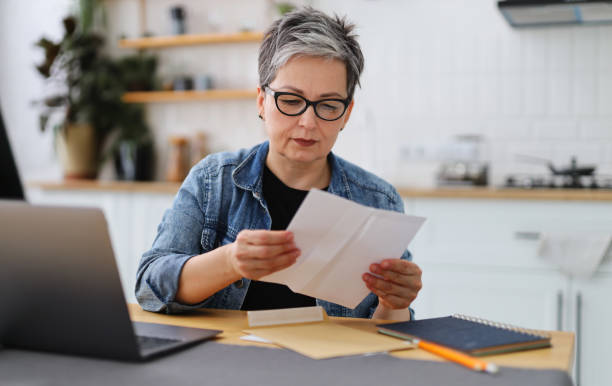 upset mature woman reading house eviction notice. - news of the world imagens e fotografias de stock