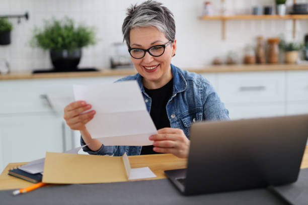 happy woman holding paper with good news, payout. - terugbetaling fotos stockfoto's en -beelden