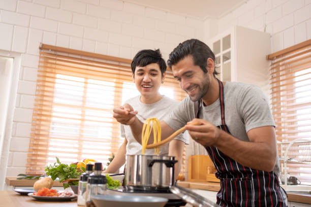 istock Two guys of different ethnicity having fun while cooking together on kitchen. 1493121126