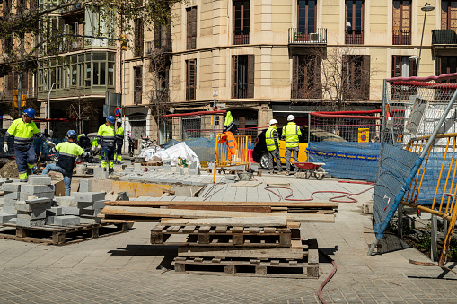 Barcelona, Spain - April 4 2023: a group of workers working on the street Consell de Cent in the construction of a superilla. Superilla are streets have been closed to the traffic and transformed in social places where people can meet