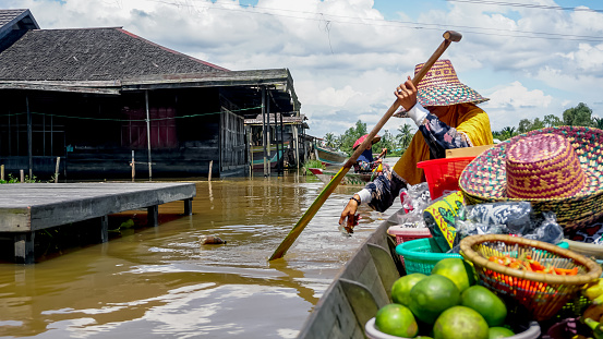 Floating market sellers clean up trash in the river by boat on the Lok Baintan river, South Kalimantan