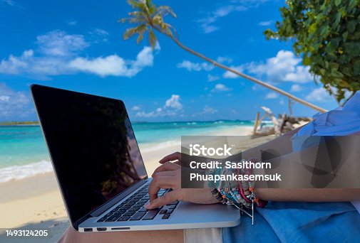 istock Nomad digital with laptop and running remotely with bright scenic view near poolside on the beach in summer time 1493124205