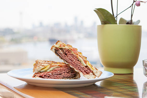 Pastrami Sandwich with a City View Enjoying a nice pastrami sandwich for lunch with a view of the city pastrami stock pictures, royalty-free photos & images