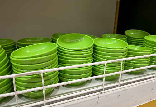 Stack of green bowls. Pile of plastic small bowls for sale display on household shop