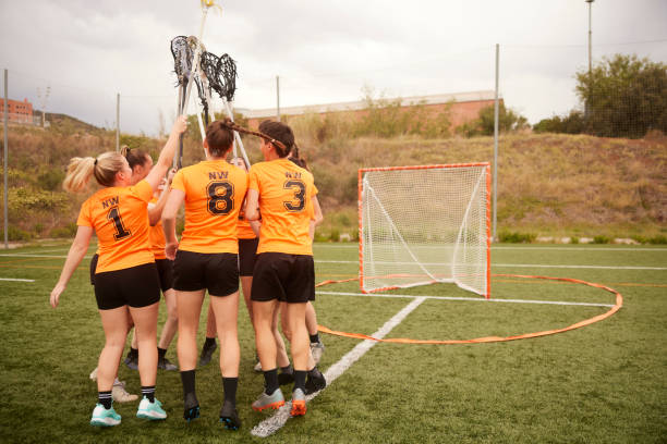istock Euphoric Lacrosse Players Celebrate Win with Raised Sticks 1493125282