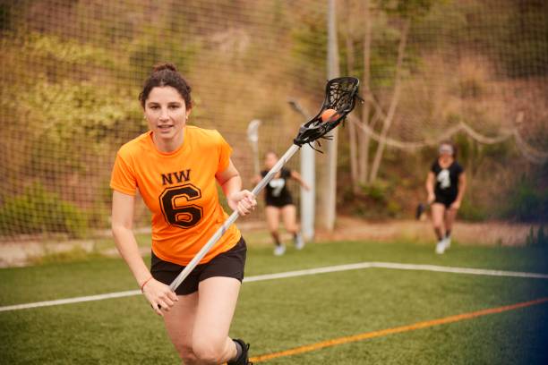 Dynamic Lacrosse Player Speeds Along the Sideline, Intense Focus with Cradled Stick