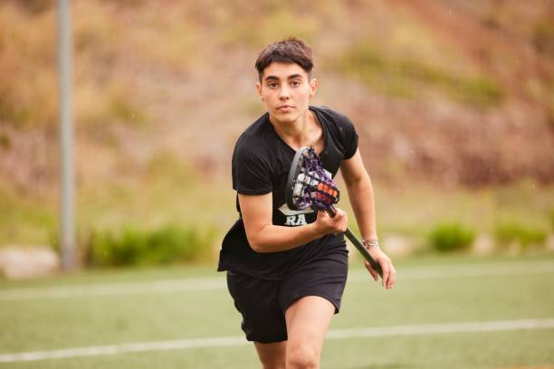 istock Charging Ahead: Lacrosse Player Runs Towards the Camera, Skillfully Cradling the Ball. 1493125306
