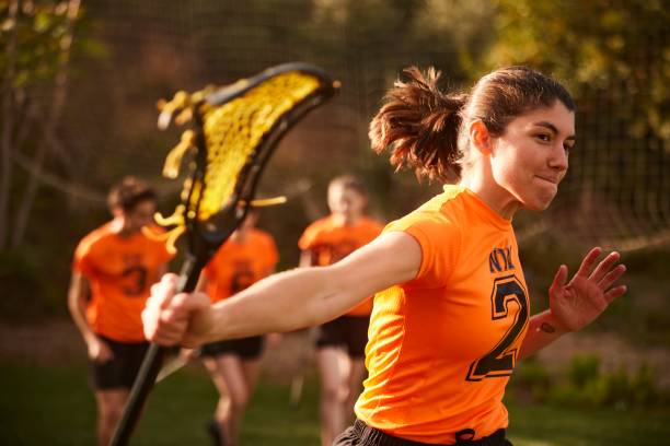 istock Victorious Dash: Female Lacrosse Player Celebrates Goal with Raised Stick 1493125984
