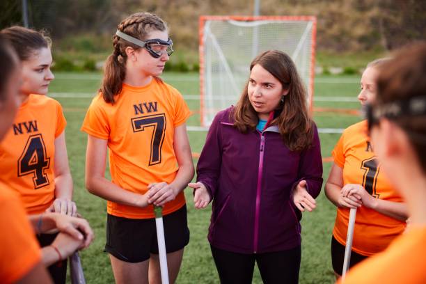 istock Strategic Coaching: Female Lacrosse Coach Directs Team Members with Expertise 1493126049