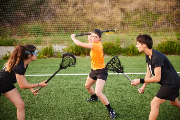 istock Free Shot Showdown: Female Lacrosse Player Faces Two Rivals in Impressive Throw 1493126053