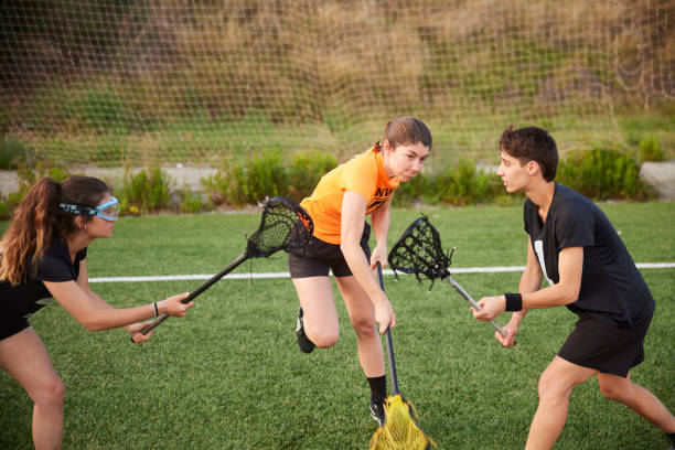 istock Strategic Maneuver: Female Lacrosse Player Executes Free Shot, Evading Two Defenders. 1493126058