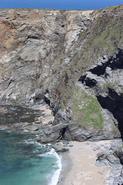 istock Dramatic cliffs overlooking a deep blue turquoise sea in a cove, with a sandy beach 1493126184
