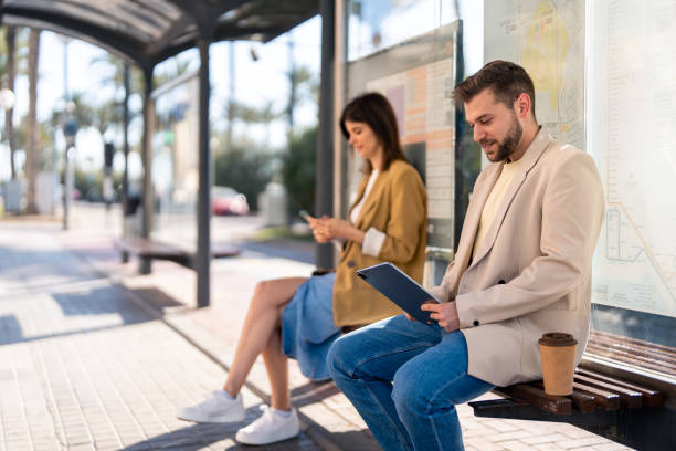 istock Confident businessman sitting at bus station using digital tablet device 1493126328