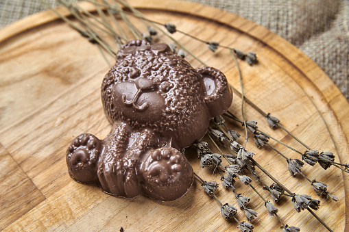 Chocolate bear on a wooden tray in a New Year's theme close-up photo