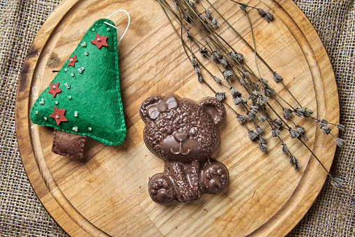 Chocolate bear on a wooden tray in a New Year's theme close-up photo