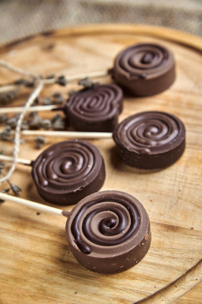 istock Round milk chocolate sweets on a stick, on a wooden tray 1493130006