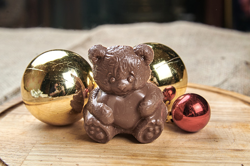 Chocolate bear on a wooden tray in a New Year's theme close-up photo