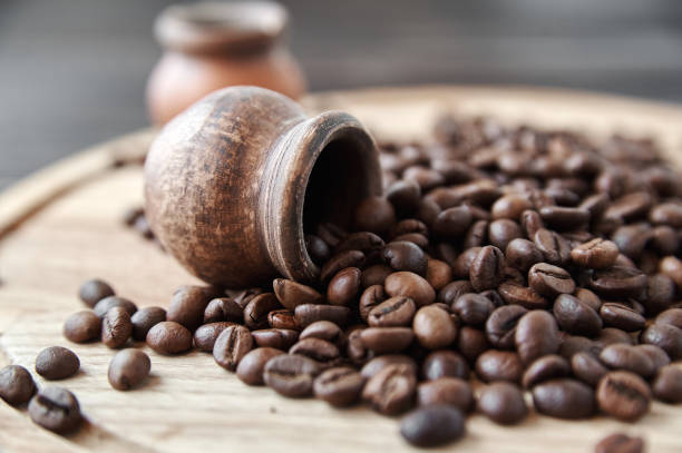 istock coffee beans with clay pot on a wooden tray, dark background 1493130965