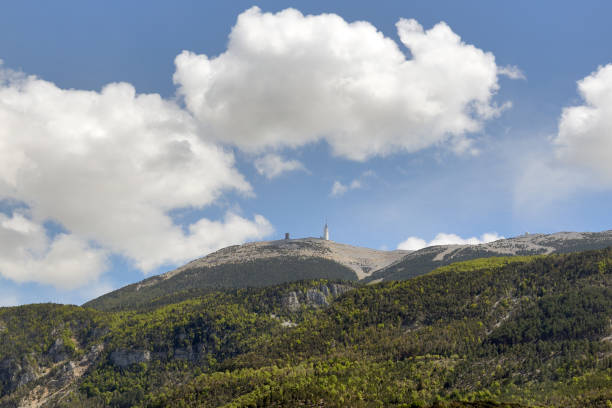 Bedoin, France - August 7, 2022:  People sitting on a weathered bench. At 1,909 m (6,263 ft), it is the highest mountain in the region and has been nicknamed the Beast of Provence.