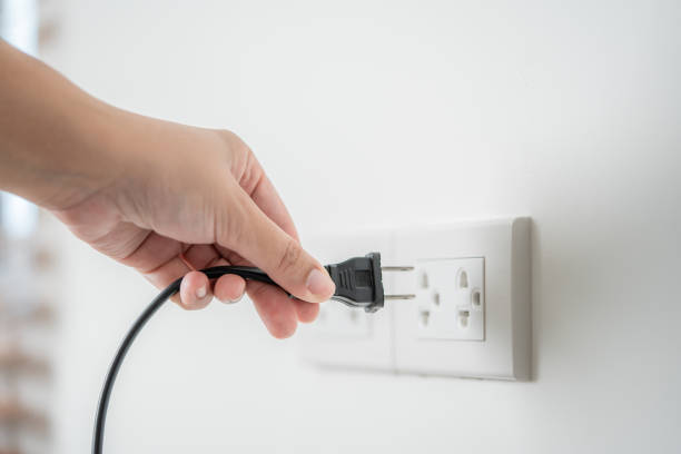istock Human hand put in or out electric plug in the socket to connect the devices 1493132933