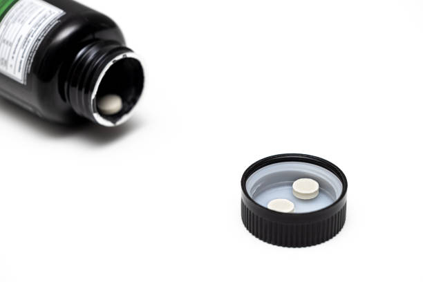istock pills lie in a bottle cap on a white background. 1493133243