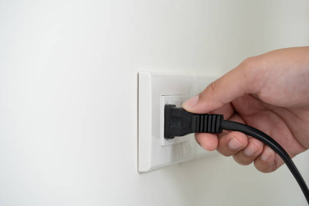 istock Human hand put in or out electric plug in the socket to connect the devices 1493133422