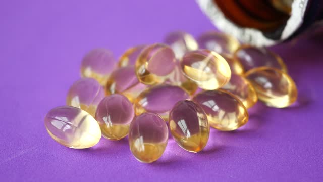Fish oil capsules vitamin D in a glass bottle