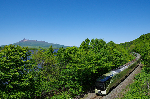 Hokuto-city, Hokkaido, Japan - May 24, 2023 : Clear blue sky, Mt.Komagatake and TRAIN SUITE “SHIKI-SHIMA”