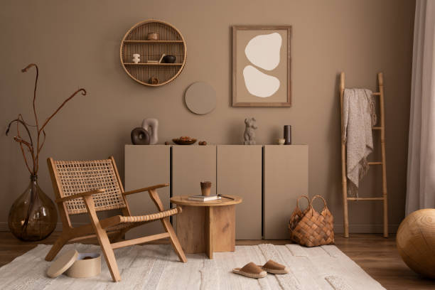 Warm and cozy composition of living room interior with mock up poster frame, rattan chair, beige rug, wooden coffee table, brown wall, plaid, ladder and personal accessories. Home decor. Template. composición cálida y acogedora del interior de la sala de estar con marco de póster de maqueta, silla de ratán, alfombra beige, mesa de centro de madera, pared marrón, cuadros, escalera y accesorios personales. decoración del hogar. plantilla.