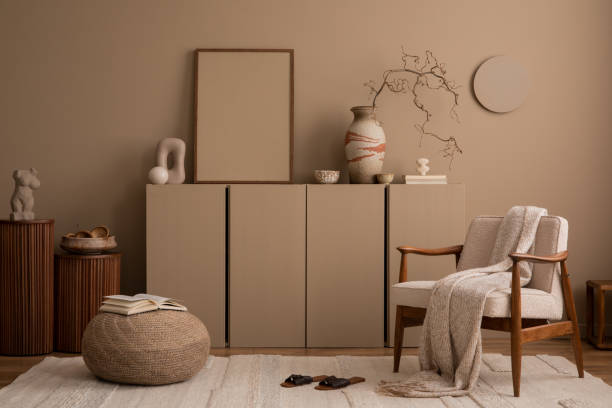 istock Aesthetics composition of living room interior with mock up poster frame, brown wall, sideboard, boucle armchair, sculpture, braided pouf, plaid and personal accessories. Home decor. Template. 1493136796