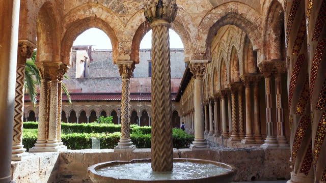 Ancient medieval stone fountain, Monreale Cathedral cloister with columns in summer. Medieval byzantine fountain. Duomo of Monreale, Palermo, Italy