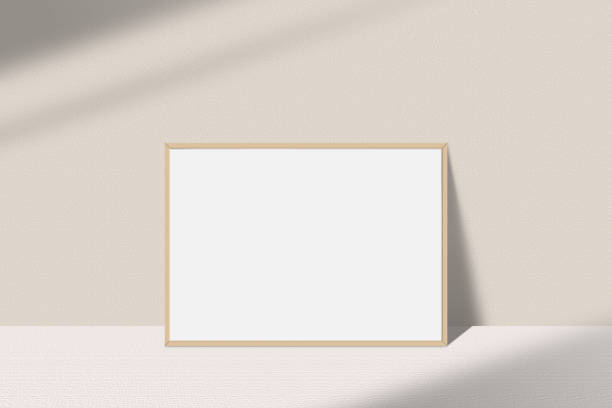 istock Realistic landscape photo frame mockup. Wooden frame mockup on the table with light window shadow overlay effect. Simple, clean, modern, minimal empty poster frame mock up. White picture frame mockup 1493142173