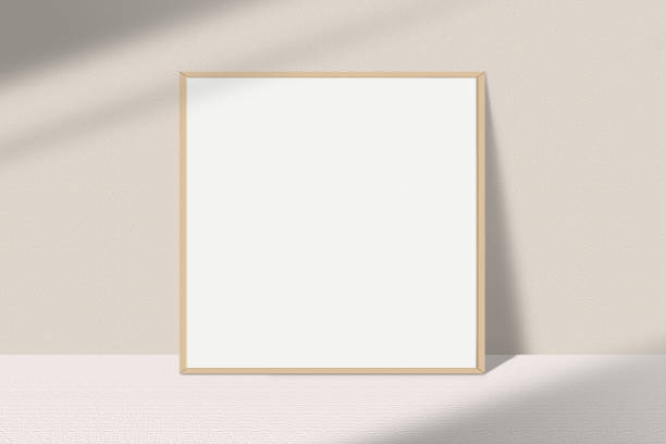 istock Realistic square photo frame mockup. Wooden frame mockup on the table with light window shadow overlay effect. Simple, clean, modern, minimal empty poster frame mock up. White picture frame mockup 1493142200