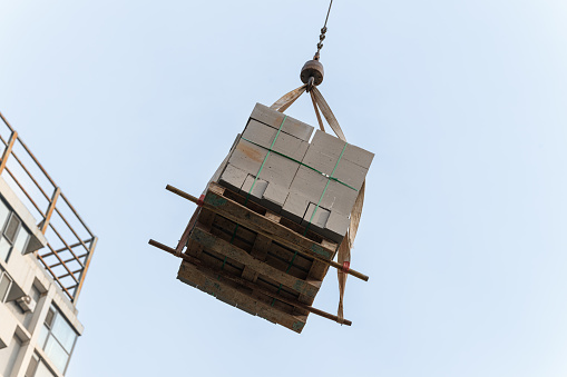 Unloading of building materials by crane at the construction site