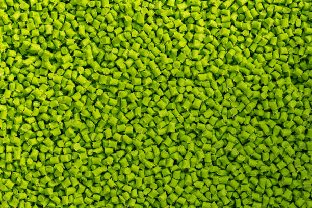 Close-up of light green plastic resin (Masterbatch) spread on a tray