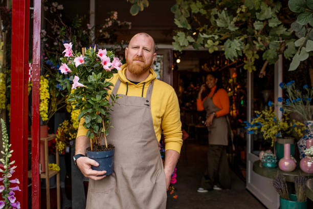 istock Handsome redhead florist working in a local flower shop 1493149734